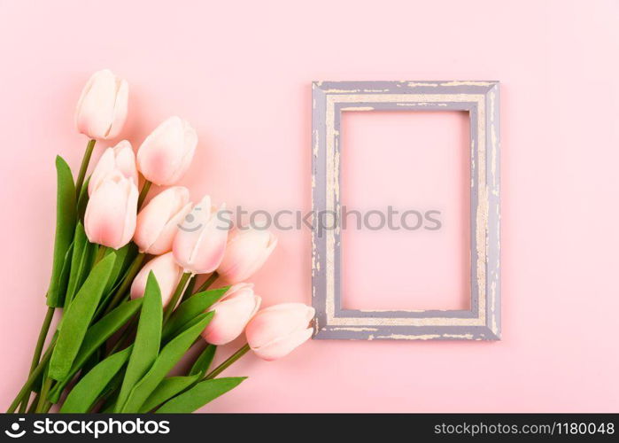 Happy Women&rsquo;s Day, Mother&rsquo;s Day concept. top view flat lay photo frame and Tulip flower on pink background, copy space for your text