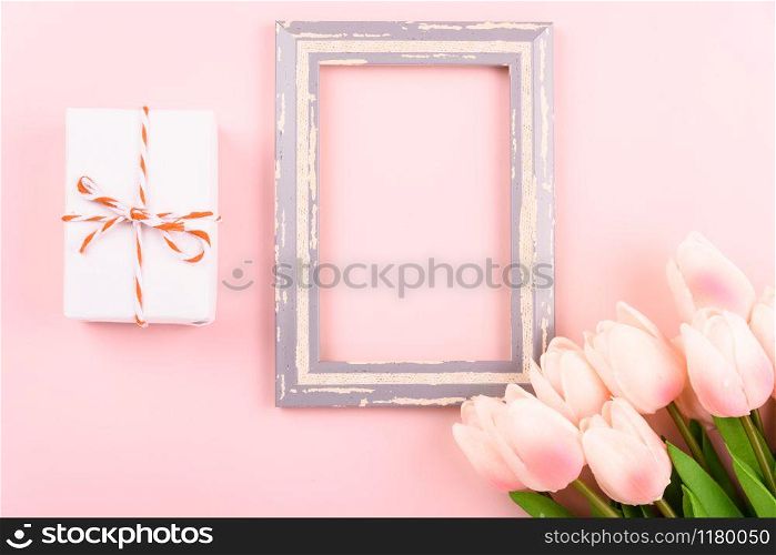 Happy Women&rsquo;s Day, Mother&rsquo;s Day concept. top view flat lay photo frame, gift box and Tulip flower on pink background, copy space for your text