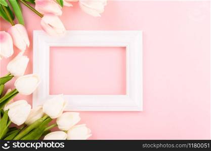 Happy Women&rsquo;s Day, Mother&rsquo;s Day concept. top view flat lay Tulip flower and photo frame on pink background, copy space for your text