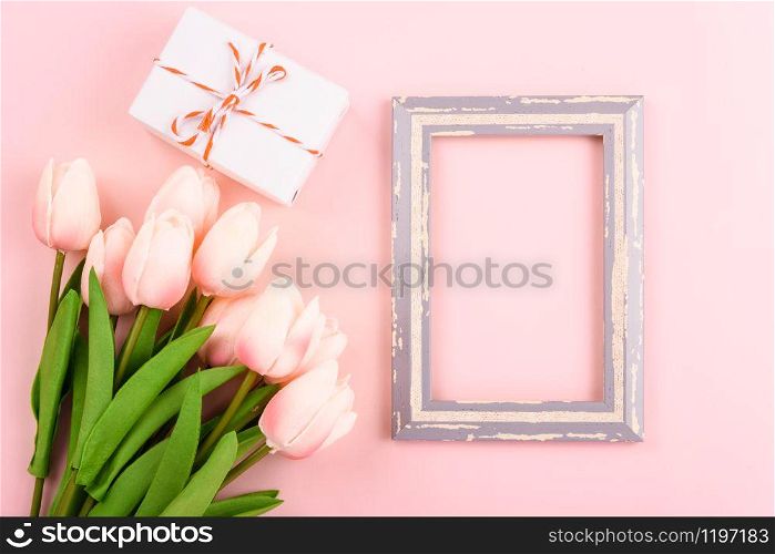 Happy Women&rsquo;s Day, Mother&rsquo;s Day concept. top view flat lay photo frame and Tulip flower on pink background, copy space for your text