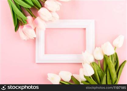 Happy Women&rsquo;s Day, Mother&rsquo;s Day concept. top view flat lay Tulip flower and photo frame on pink background, copy space for your text