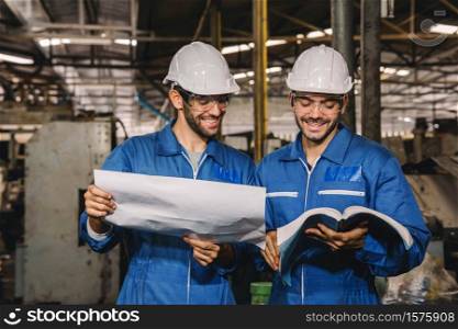 Happy Work. Factory Engineer with white safety helmet smile and relax talk during work on production in a factory. Industrial,Warehouse Heavy Mechanic, Engineering Concept.