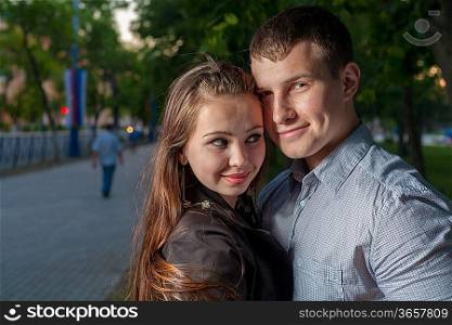 Happy young adult couple dancing outdoors at night