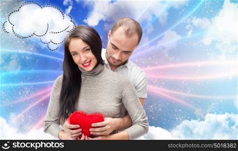 Happy young adult couple with red heart on romantic background with sky and clouds, embracing and laughing. Lots of copyspace