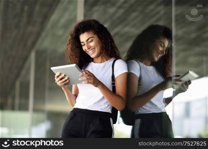 Happy young Arab woman using digital tablet in business background. Happy girl wearing sportswear.. Happy young Arab woman using digital tablet in business background.