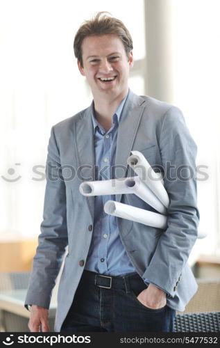happy young architect business man portrait with paper blueprints plan