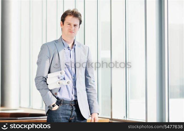 happy young architect business man portrait with paper blueprints plan