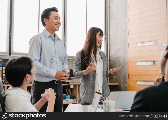 Happy young Asia businessmen and businesswomen meeting brainstorming ideas about new paperwork project colleagues working together planning success strategy enjoy teamwork in small modern office.