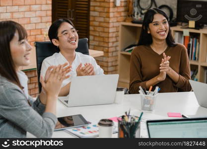 Happy young Asia businessmen and businesswomen meeting brainstorming ideas about new paperwork project colleagues working together planning success strategy enjoy teamwork in small modern office.