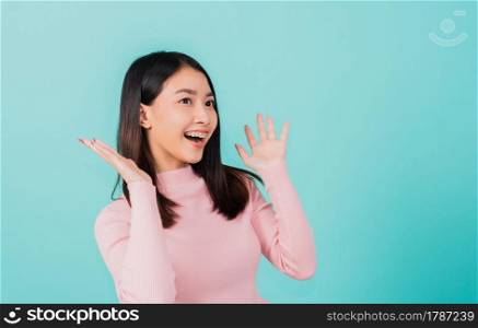 Happy young Asian beautiful woman smiling wear silicone orthodontic retainers on teeth surprised she is excited screaming and raise hand make gestures wow, studio shot isolated on blue background