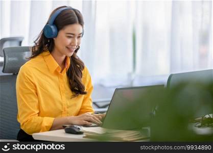Happy young asian business woman wears headset talk to online video conference call with her business team at modern office or Co-working space,Business Startup Concept