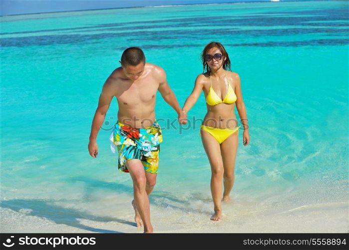 happy young asian couple have fun and romantic time at summer on beautiful white sand beach