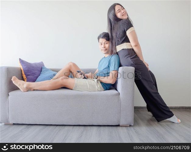 Happy young Asian couple in love relaxing on the sofa.