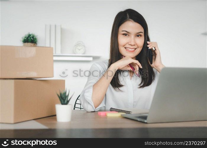 Happy young Asian woman entrepreneur, talk with a supplier and Smile for sale success of online shopping store at home office, Concept of the merchant, small business, online business, and eCommerce.