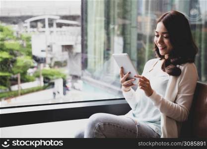 Happy young Asian woman using digital tablet and feeling happiness while reading ebook, Media book library or study on E-learning online concept