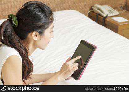happy young asian woman working with tablet in bedroom