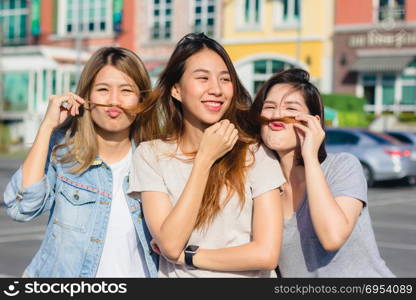 Happy young Asian women group city lifestyle playing and chatting each other among the pastel building city on weekend. City lifestyle of girls group. City lifestyle and outdoor activity concept.