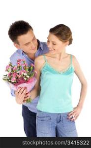 Happy young attractive casual couple in love, man giving flowers to a woman, isolated on white
