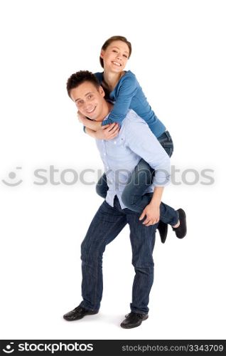 Happy young attractive couple having fun, man giving woman piggyback ride, isolated over white background