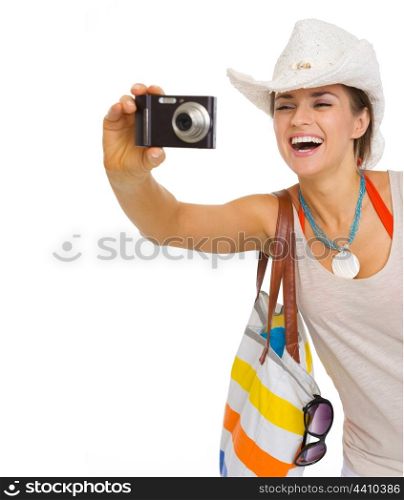 Happy young beach woman in hat taking photo