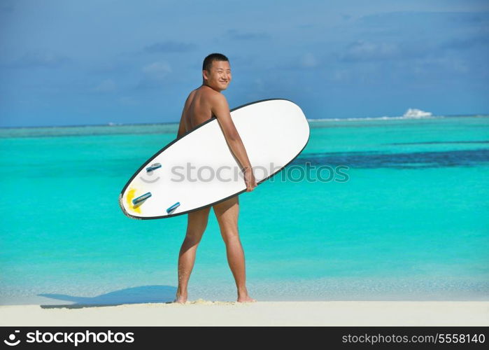 happy young beautiful asian woman relax on sand at tropical beach with cristal clear sea in background