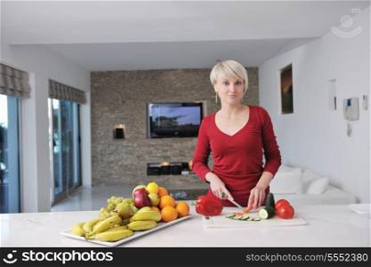 happy young beautiful blonde woman prepare food in the kitchen at home