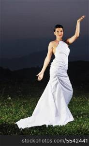 happy young beautiful bride after wedding ceremony event have fun on meadow in fashionable wedding dress