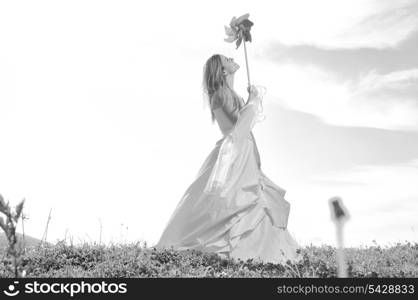 happy young beautiful bride after wedding ceremony event have fun outdoor on meadow at sunset with windmill toy and representing smart energy