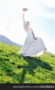 happy young beautiful bride after wedding ceremony event have fun outdoor on meadow at sunset with windmill toy and representing smart energy