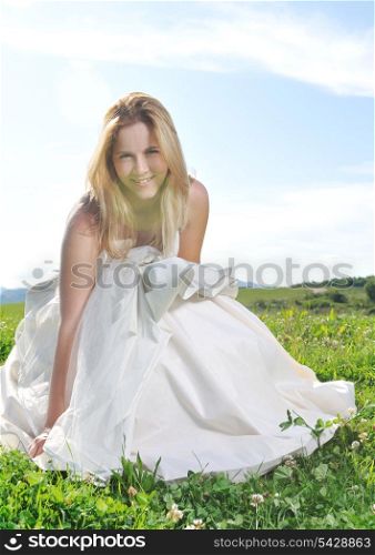 happy young beautiful bride after wedding ceremony event have fun outdoor on meadow at sunset