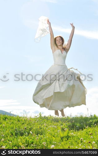 happy young beautiful bride after wedding ceremony event have fun outdoor on meadow at sunset