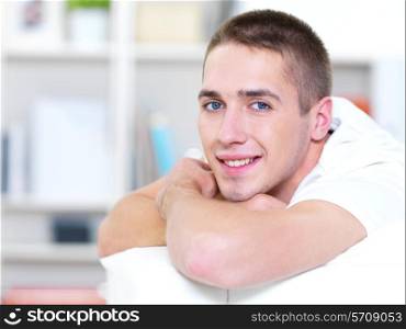 happy young beautiful man lying on the sofa