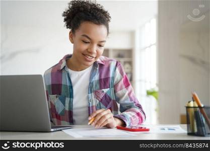 Happy young biracial girl student learning at laptop look at smartphone screen chatting in social network. Schoolgirl teenage distracted from school tasks, homework. Gadget addiction concept.. Biracial girl student learning at laptop look at smartphone, distracted from study. Gadget addiction