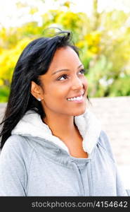 Happy young black woman looking to the side outdoors in fall