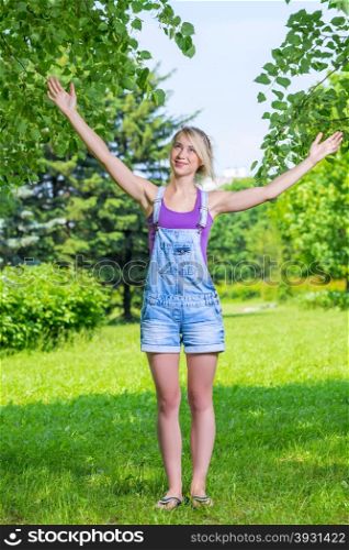 Happy young blond woman with arms outstretched