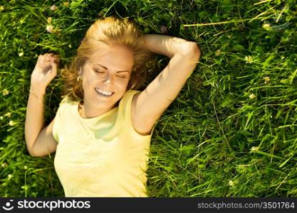 happy young blonde relaxing on the grass