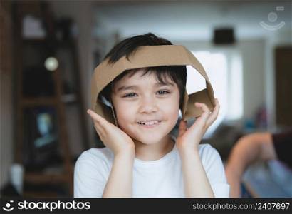 Happy young boy using cardboard for headphone, Active Kid with big smile while playing cardbox, Positive child relaxing at home on weekend, DIY Recyling toys idea for Children