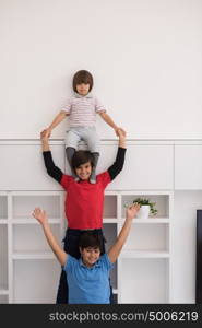 happy young boys having fun and posing line up piggyback in new modern home