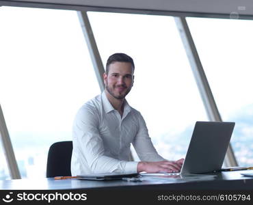 happy young business man work and relax at modern bright office interior, hipster with beard at workplace