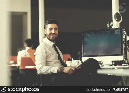 happy young business man working on desktop computer at his desk in modern bright startup office interior
