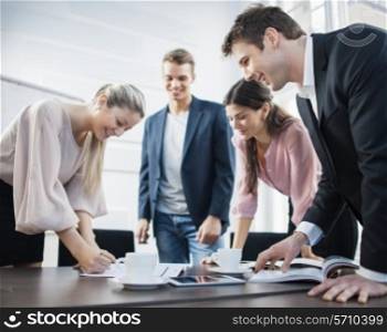 Happy young business people brainstorming at conference table