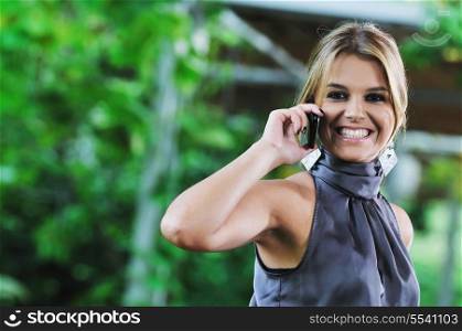 happy young business woman in fashionable clothing talking on cellphone outdoor