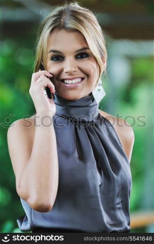 happy young business woman in fashionable clothing talking on cellphone outdoor