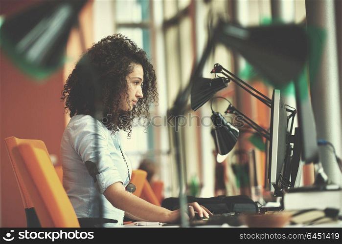 happy young business woman with curly hairstyle in the modern office