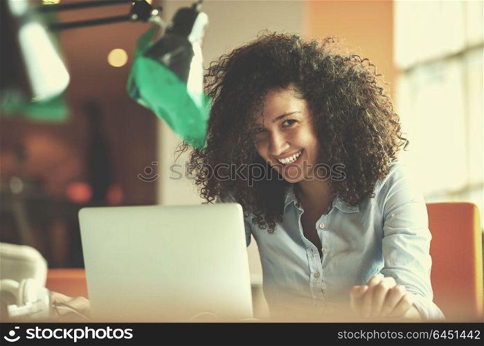 happy young business woman with curly hairstyle in the modern office