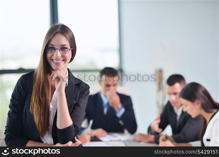happy young business woman with her staff, people group in background at modern bright office indoors