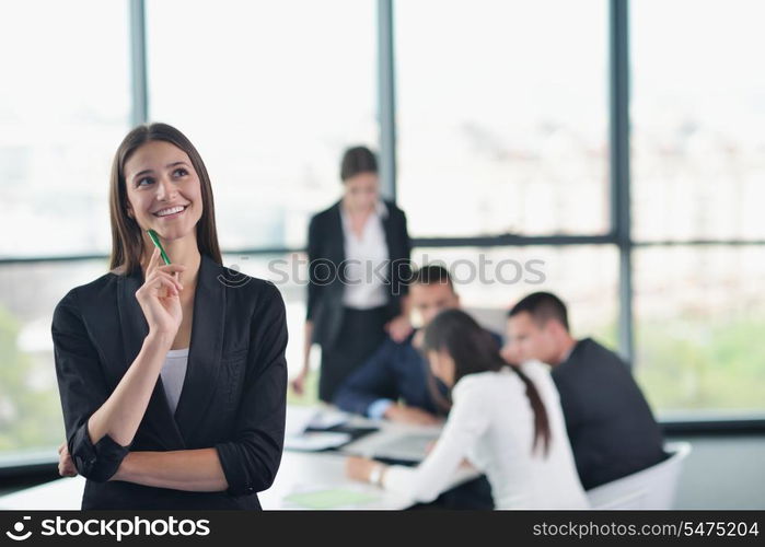 happy young business woman with her staff, people group in background at modern bright office indoors