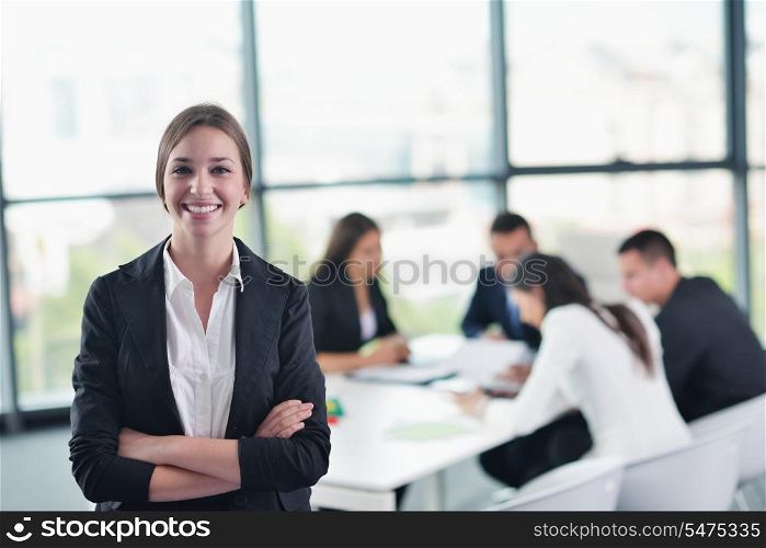 happy young business woman with her staff, people group in background at modern bright office indoors