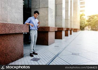 Happy Young Businessman in Casual wear Using Mobile Phone in the City. Lifestyle of Modern People. Full Length