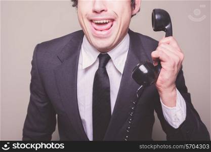 Happy young businessman is on the phone
